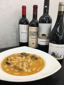 un plato de comida con un tazón de pasta y vino en Las Cadenas en Ledesma