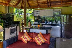 a kitchen with a couch with pillows on it at Villa Amber in Laem Set Beach