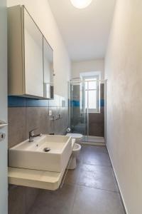 Un baño con lavabo, inodoro y espejo. en Casa Turano, en Castellammare del Golfo