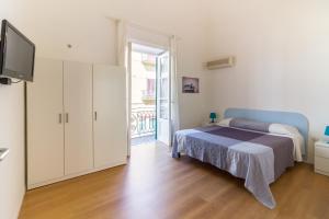 Un dormitorio con una cama y un televisor en una habitación. en Casa Turano, en Castellammare del Golfo