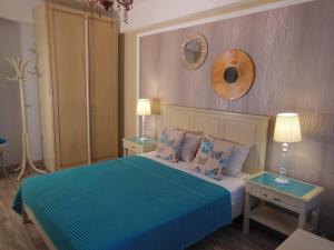 ママイアにあるGabrielle Apartmentのベッドルーム1室(青いシーツとテーブル2台付)
