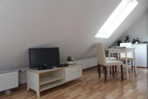 a living room with a tv and a table with a dining room at Flughafenapartement Sky View in Düsseldorf