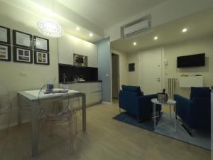 ein Wohnzimmer mit einem Tisch und Stühlen sowie eine Küche in der Unterkunft Parma City Centre Holiday House in Parma