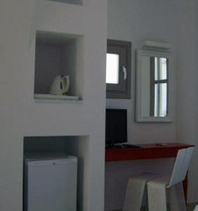 Camera bianca con tavolo, finestra, tavolo e sedia di Mar Inn Hotel a Chora Folegandros
