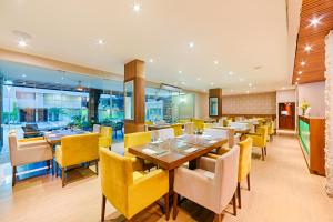 a dining room with yellow chairs and tables at Hotel Arizona Suites Cúcuta in Cúcuta