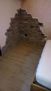 Cette chambre est dotée d'un mur en briques à côté d'un lit. dans l'établissement Camera Fenis, à Fenis