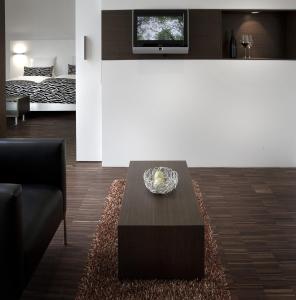 a living room with a coffee table and a bed at BECKER´S Hotel & Restaurant in Trier