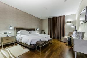 um quarto de hotel com uma cama grande e uma casa de banho em Hotel Villa Batalha na Batalha