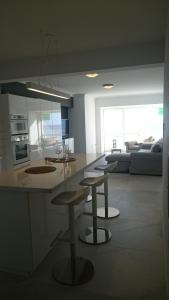 - une cuisine avec deux tabourets et un comptoir dans une pièce dans l'établissement lounge appartement zeedijk Oostende, à Ostende