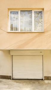 un bâtiment avec une porte de garage et une fenêtre dans l'établissement Ibar Apartment & Garage, à Plovdiv