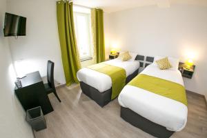 two beds in a hotel room with green curtains at Grand Hotel De France in Meyrueis