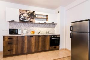 une cuisine avec des armoires en bois et un réfrigérateur en acier inoxydable dans l'établissement Ibar Apartment & Garage, à Plovdiv 10 autres photos