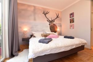 バート・ハルツブルクにあるEcht-Harz-Fewoのベッドルーム1室(鹿の頭が壁に掛けられたベッド1台付)