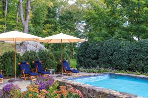 a group of chairs and umbrellas next to a pool at Bedford Post Inn in Bedford