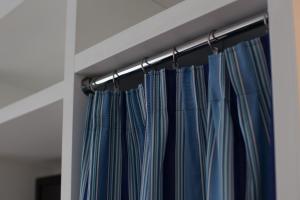 a curtain rod with blue curtains in a room at Hotel Mignon Meublè in Sorrento