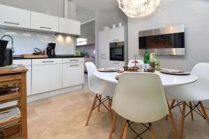 a kitchen with white cabinets and a white table and chairs at Echt-Harz-Fewo in Bad Harzburg