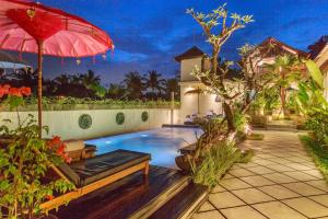 uma casa com uma piscina com um guarda-sol vermelho em Solo Villas & Retreat em Ubud