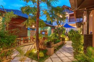 a courtyard of a house with a palm tree at Solo Villas & Retreat in Ubud