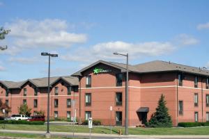 ein großes rotes Backsteingebäude mit einem grünen Schild darauf in der Unterkunft Extended Stay America Suites - Philadelphia - Airport - Bartram Ave in Philadelphia