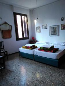 two twin beds in a room with a window at Cà Widmann in Venice