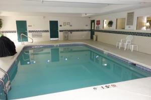 a large swimming pool with blue water in a building at Country Inn & Suites by Radisson, McDonough, GA in McDonough