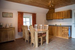 cocina con mesa de madera y sillas en Fox House, en Pelči