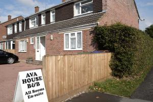 a house with a sign in front of a fence at Ava House Bed and Breakfast in Bicester
