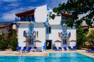 a villa with a swimming pool in front of a building at Dove Apart Hotel in Fethiye