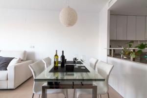 a dining room with a glass table and white chairs at Cabo Roig Terrazas de Campoamor 25 in Playas de Orihuela