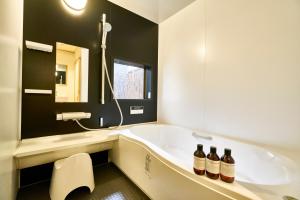 a bathroom with a tub and two bottles of alcohol at Mibuan in Kyoto +50 photos