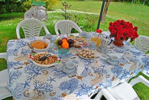 una mesa azul y blanca con comida y flores. en B&B Marienn, en Gavardo