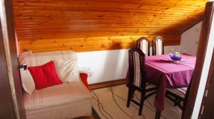 a room with a table and a couch and a table and chair at Apartment Gajevi in Zlatibor