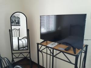una televisión en un puesto junto a un espejo en Lindavista La Paz Apartamento, en La Paz
