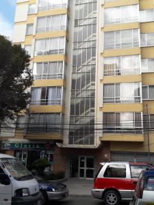 un edificio alto con coches estacionados frente a él en Lindavista La Paz Apartamento, en La Paz