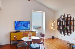 a living room with a table and chairs and a tv at Villefranche Sur Mer One Bed in Villefranche-sur-Mer