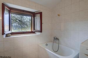 Un baño con bañera y ventana. en La Calla, en Monghidoro 47 fotos más