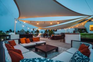 a patio with couches and a table and lights at Las Terrazas Resort in San Pedro