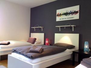 two beds in a room with black walls at Arena City Apartment Buer in Gelsenkirchen
