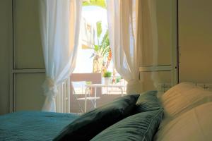a bedroom with a bed and a window with curtains at Villa Alba in Acitrezza