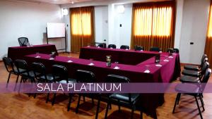 una sala conferenze con tavoli e sedie viola di Blub Hotel Spa a Huancayo