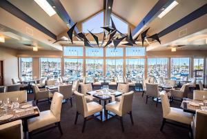 a restaurant with tables and chairs and a large window at Humphreys Half Moon Inn in San Diego