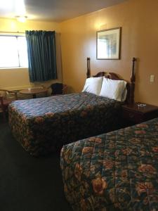 um quarto de hotel com duas camas e uma mesa em Deluxe Inn em Hebron