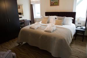 um quarto com uma cama grande e toalhas em The Waterfront Boutique Hotel em Stanley