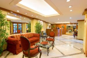 eine Lobby mit einem Sofa, einem Tisch und Stühlen in der Unterkunft The Manor Hotel in Davao City