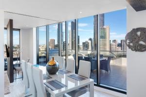 a dining room with a view of the city at Aura on Flinders Serviced Apartments in Melbourne