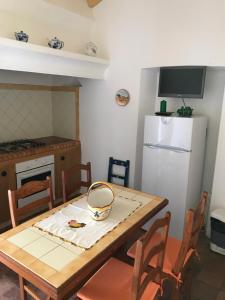 eine Küche mit einem Holztisch und einem weißen Kühlschrank in der Unterkunft Monte Antonio Domingos in Melides
