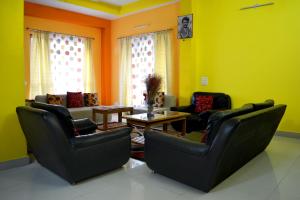 uma sala de estar com duas cadeiras e uma mesa em Kashyap Kunj em Gangtok