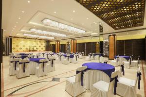 a banquet hall with white and blue tables and chairs at Hotel Millennium in Guwahati