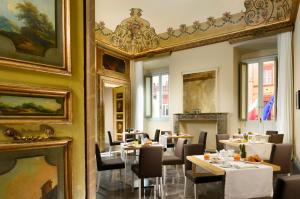 a dining room with tables and chairs and a mirror at Locanda della Posta - Etruria Collection in Perugia