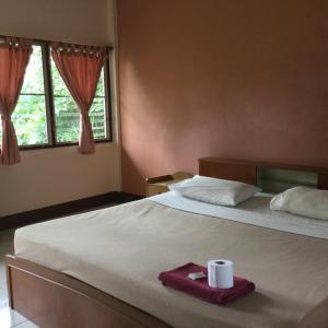 Un dormitorio con una cama con una toalla. en Baan Bua Guest House en Chiang Rai